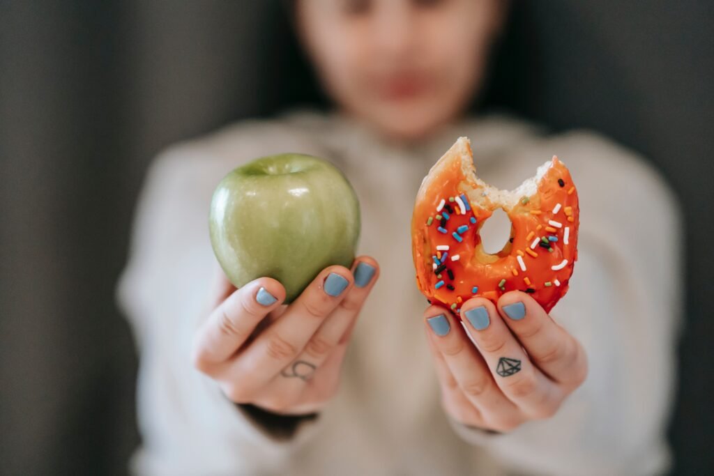 Girl holding an apple and donut